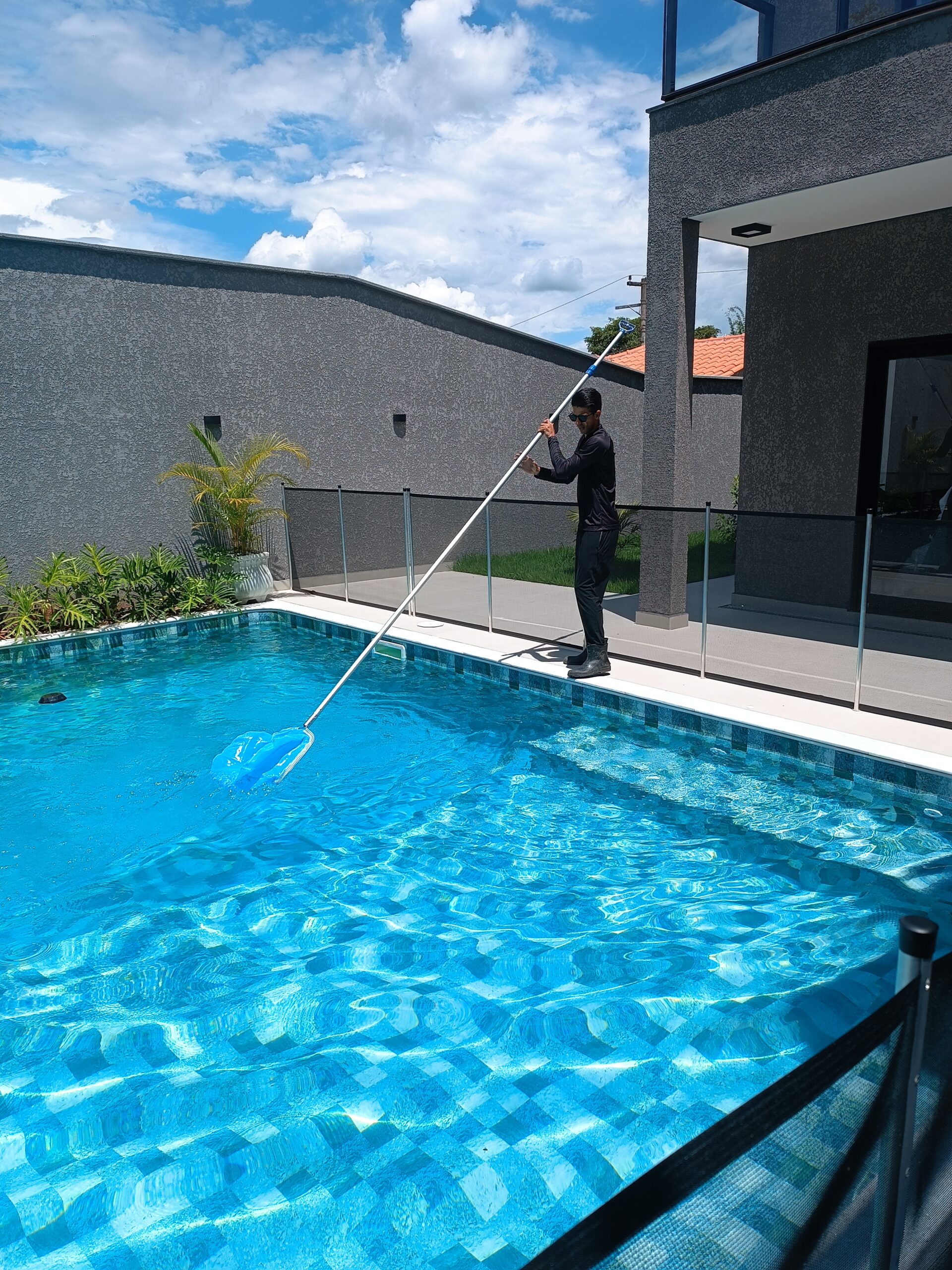 T&eacute;cnico realizando tratamento de piscina de alto padr&atilde;o com &aacute;gua cristalina. Servi&ccedil;o especializado de an&aacute;lise qu&iacute;mica, balanceamento da &aacute;gua, aspira&ccedil;&atilde;o, escova&ccedil;&atilde;o e uso de produtos adequados para garantir limpeza, seguran&ccedil;a e economia na manuten&ccedil;&atilde;o da piscina.